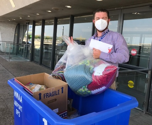 Man places bags in blue crate